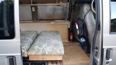 This is camperized interior with the rear seat folded down for the bed. Note cabinet, small sink and camper manual faucet.