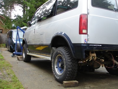 Here she sits finally on her own wheels. <br />2 inch body lift in front, with mildly turned up torsion bars for about 3-4 inch front.<br />OLV Shackles and NO blocks, with S-10 springs I got locally. they had about 7.5 inches of free arc.<br />I almost think I should put stock shackles back in it to level it out.